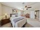 Well-lit bedroom with a ceiling fan, shuttered windows, and an ensuite bathroom at 8104 Wispy Sage Way, Las Vegas, NV 89149