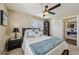 Comfortable bedroom featuring a ceiling fan, cozy bedding, and a view to another bedroom at 8104 Wispy Sage Way, Las Vegas, NV 89149