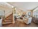 Elegant living room with staircase, neutral color palette, large windows and access to the dining room at 8104 Wispy Sage Way, Las Vegas, NV 89149