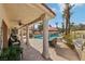 Covered patio with ceiling fan overlooks the sparkling pool, rock waterfall, and tropical landscaping at 8104 Wispy Sage Way, Las Vegas, NV 89149