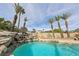 Beautiful swimming pool featuring a waterfall and palm trees at 8104 Wispy Sage Way, Las Vegas, NV 89149