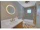 Stylish bathroom with geometric tile, vanity with gold fixtures, and a circular mirror at 819 Bracken Ave, Las Vegas, NV 89104