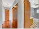 Hallway with hardwood floors, closet doors, and a view into a uniquely tiled bathroom at 819 Bracken Ave, Las Vegas, NV 89104