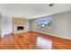 Bright living room with hardwood floors, a brick fireplace, and a large window at 819 Bracken Ave, Las Vegas, NV 89104