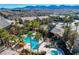 Aerial view of the community pool with spa, rock feature and covered seating area surrounded by palm trees at 8250 N Grand Canyon Dr # 2029, Las Vegas, NV 89166
