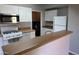 Galley kitchen boasts white cabinets and a breakfast bar at 8250 N Grand Canyon Dr # 2029, Las Vegas, NV 89166