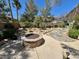Backyard landscaping with built-in fire pit and trees at 8777 Beckett Ridge Ave, Las Vegas, NV 89149