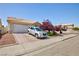 Traditional home featuring a two-car garage and lush landscaping in front at 9091 W Viking Rd, Las Vegas, NV 89147