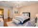 A comfortably furnished bedroom with warm colors, hardwood floors, and modern light fixture at 9500 Balatta Canyon Ct, Las Vegas, NV 89144