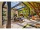 Outdoor dining area with pergola, mature trees, and a built-in grill at 9500 Balatta Canyon Ct, Las Vegas, NV 89144