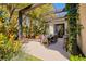 Covered patio with dining table, lush landscaping, and elegant lighting at 9500 Balatta Canyon Ct, Las Vegas, NV 89144