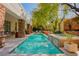Beautiful pool and spa with stone accents, surrounded by mature trees and manicured landscaping at 9500 Balatta Canyon Ct, Las Vegas, NV 89144