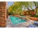 Sparkling swimming pool with a waterfall feature, surrounded by lush landscaping at 9500 Balatta Canyon Ct, Las Vegas, NV 89144
