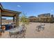 Landscaped backyard featuring decorative rock, covered patio and wrought iron furniture creating an inviting outdoor space at 12429 Alpenglow Ct, Las Vegas, NV 89138