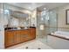 Bright bathroom boasts dual sink vanity with wood cabinets, a soaking tub, and glass enclosed shower at 125 E Harmon Ave # 2907, Las Vegas, NV 89109