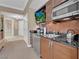 Convenient kitchenette with stainless steel appliances, a mounted television, and modern cabinets with black countertops at 125 E Harmon Ave # 2907, Las Vegas, NV 89109