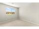 Bright bedroom featuring a large window with views of the outdoors and neutral carpeting at 160 Lomita Heights Dr, Las Vegas, NV 89138