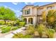 Inviting two-story home with lush landscaping, covered porch, and charming architectural details at 160 Lomita Heights Dr, Las Vegas, NV 89138