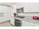 Modern kitchen featuring granite countertops, stainless steel appliances, and sleek white cabinetry at 160 Lomita Heights Dr, Las Vegas, NV 89138