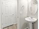 Stylish powder room features a pedestal sink, round mirror, and modern fixtures at 160 Lomita Heights Dr, Las Vegas, NV 89138