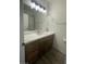 Bathroom vanity features wood cabinets, light countertop, and large mirror at 1785 Puerto Way, Henderson, NV 89012