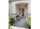 Inviting front porch with bench seating, decorative door, and desert plants at the entrance of the home at 1785 Puerto Way, Henderson, NV 89012