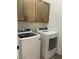 Convenient laundry room featuring a modern washer and dryer, cabinets for storage, and neutral paint at 1785 Puerto Way, Henderson, NV 89012
