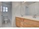 Well-lit bathroom featuring a double vanity, large mirror, and a toilet at 2388 Kenneth Ave, Henderson, NV 89052