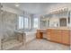 Spacious bathroom featuring a walk-in shower, soaking tub, and a wooden vanity area at 2388 Kenneth Ave, Henderson, NV 89052
