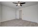 Neutral carpeted bedroom with a ceiling fan and a doorway leading to another room at 2388 Kenneth Ave, Henderson, NV 89052
