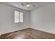 This well-lit bedroom features wood-look floors, a ceiling fan, and white walls at 2388 Kenneth Ave, Henderson, NV 89052