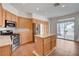 This eat-in kitchen features stainless steel appliances, light wood cabinets and an island with backyard access at 2388 Kenneth Ave, Henderson, NV 89052