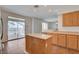 Bright kitchen with light wood cabinets, an island, tile floors and sliding glass doors to the backyard at 2388 Kenneth Ave, Henderson, NV 89052