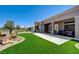 A well-manicured backyard with artificial grass, cacti, and a patio with seating and a view of the golf course at 2625 Youngdale Dr, Las Vegas, NV 89134