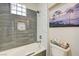 Clean bathroom featuring tiled bathtub and shower with glass-block window and decorative accents at 2625 Youngdale Dr, Las Vegas, NV 89134