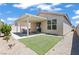 Inviting backyard featuring a covered patio, artificial grass, and a tranquil outdoor space at 2633 Chin Cactus Ct, Las Vegas, NV 89106