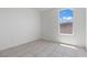 Well-lit bedroom showcasing neutral walls, tile flooring, and a window with views at 2633 Chin Cactus Ct, Las Vegas, NV 89106