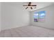 Comfortable bedroom with tile flooring, a ceiling fan, and a large window offering natural light at 2633 Chin Cactus Ct, Las Vegas, NV 89106