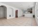 Spacious living room featuring tile flooring, arched doorways, and ample natural light from the large window at 2633 Chin Cactus Ct, Las Vegas, NV 89106