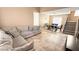 Open-concept living room with tile flooring, sectional couch, dining area, and staircase at 2722 Sweet Basil Dr, Las Vegas, NV 89142