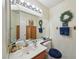 Neutral bathroom features a large mirror, wood cabinets, and vanity at 2809 Du Barry Manor Ln, Las Vegas, NV 89108