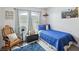 Well lit bedroom features blue bedding, gray blinds, and a wooden rocking chair at 2809 Du Barry Manor Ln, Las Vegas, NV 89108