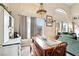 Cozy dining area with vintage-style lighting, a wooden table and bench, and views to the living area at 2809 Du Barry Manor Ln, Las Vegas, NV 89108