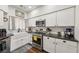 Well-lit kitchen with white cabinetry, stainless steel appliances, and a farmhouse sink for a modern touch at 2809 Du Barry Manor Ln, Las Vegas, NV 89108