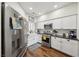 Modern kitchen with stainless steel appliances, white cabinets, and wood-look flooring for a clean look at 2809 Du Barry Manor Ln, Las Vegas, NV 89108