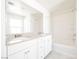 Bright bathroom featuring a double sink vanity, a large mirror and a shower and tub combination with a white tile surround at 3240 Avernus Ave, Henderson, NV 89044