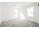 Bright bedroom featuring gray carpet, two windows, and fresh white paint at 3240 Avernus Ave, Henderson, NV 89044