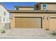 A two-car garage with brown doors and brick paver driveway under a clear blue sky at 3240 Avernus Ave, Henderson, NV 89044