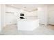 A modern kitchen with white cabinets, a large island with a quartz countertop, and stainless-steel appliances at 3240 Avernus Ave, Henderson, NV 89044