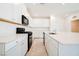 Modern kitchen with white cabinets, a large island with quartz countertop, and stainless-steel appliances at 3240 Avernus Ave, Henderson, NV 89044